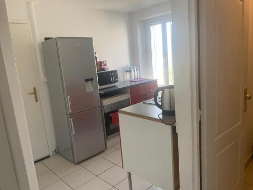 une cuisine avec un réfrigérateur en acier inoxydable et un micro-ondes dans l'établissement Appartement t2, à Orléans