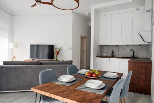 a kitchen and living room with a wooden table and chairs at SKi&bike apartments Laguna Zarzecze in Zarzecze
