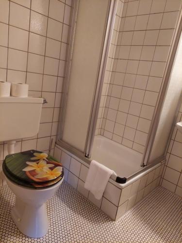 ein Badezimmer mit einer Dusche und einem WC mit einem Obstteller darauf in der Unterkunft Gasthaus zur Krone in Weisenbach