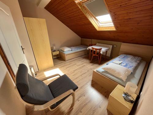 Habitación pequeña con cama y silla en Penzión D+D, en Zázrivá