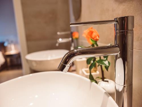 a bathroom sink with a faucet with a flower on it at B&B Casa di Gio' in Tiggiano