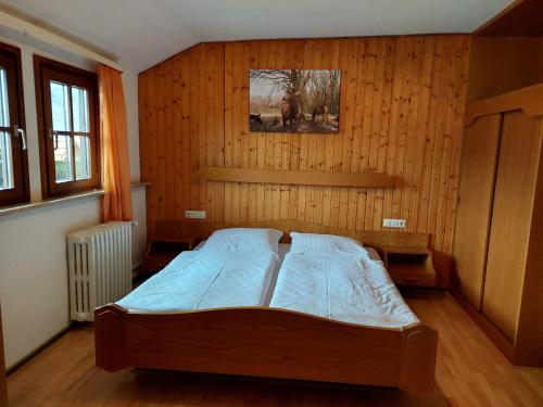 ein Schlafzimmer mit einem Bett in einer Holzwand in der Unterkunft Gasthaus zur Krone in Weisenbach