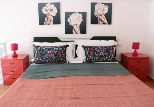um quarto com uma cama grande e 2 mesas de cabeceira vermelhas em sea home em Bacoli