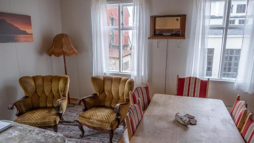 a dining room with a table and chairs and windows at Hótel Djúpavík in Djupavik