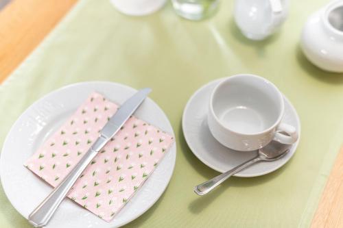 een tafel met twee borden, een kopje en een servet bij Weingut und Gastehof Borst in Nordheim