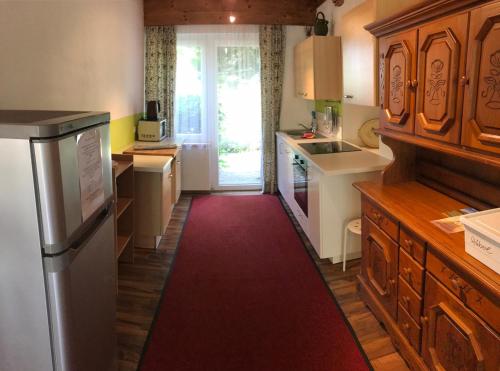 a kitchen with a red carpet in the middle of it at Georgihof im Park in Unterburg am Klopeiner See