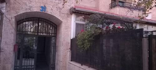 un edificio con puerta y balcón con flores en Appartamento bello e elegante in west Amman, en Amán