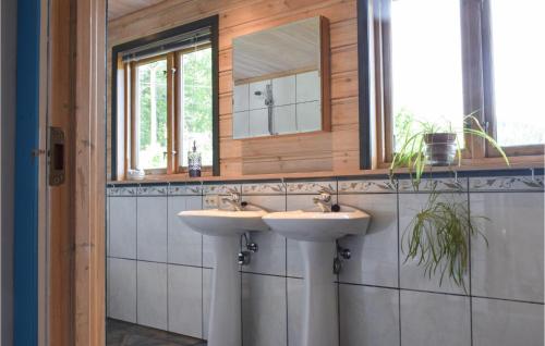 a bathroom with two sinks and a mirror at Gorgeous Home In Farsund With Kitchen in Farsund