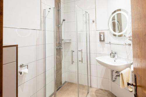 a bathroom with a glass shower and a sink at Weingut und Gastehof Borst in Nordheim