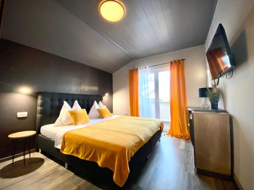 a bedroom with a large bed with a yellow blanket at Apartements and rooms next to the Sea - Belveder Rab in Rab