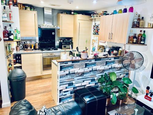 una cocina con armarios de madera y una pared de azulejos en Private room in BS14 en Bristol
