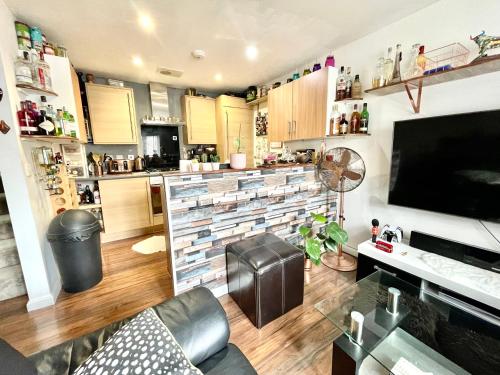 a living room with a couch and a tv and a kitchen at Private room in BS14 in Bristol