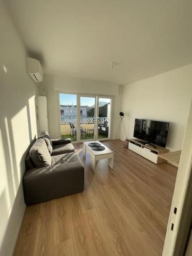 ein Wohnzimmer mit einem Sofa und einem TV in der Unterkunft Appartement la Seyne sur mer in La Seyne-sur-Mer