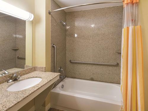 a bathroom with a tub and a sink and a shower at La Quinta by Wyndham Waxahachie in Waxahachie