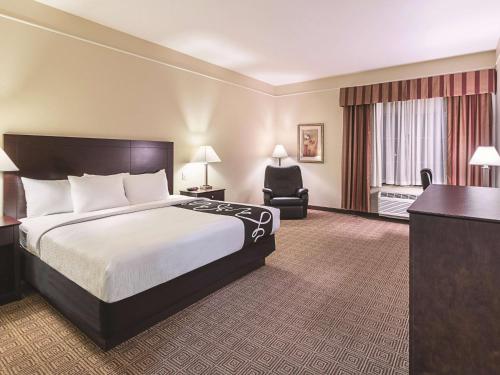 a hotel room with a bed and a desk at La Quinta by Wyndham Waxahachie in Waxahachie