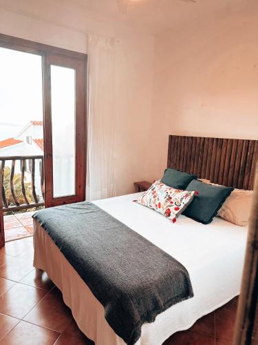 a bedroom with a large bed with a large window at Sa caseta de Fornells in Es Mercadal