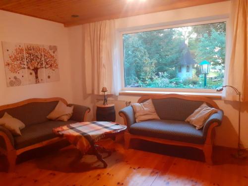 a living room with two chairs and a window at Georgihof im Park in Unterburg am Klopeiner See