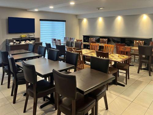 a dining room with tables and chairs and a flat screen tv at Econo Lodge Airport Quebec in Quebec City