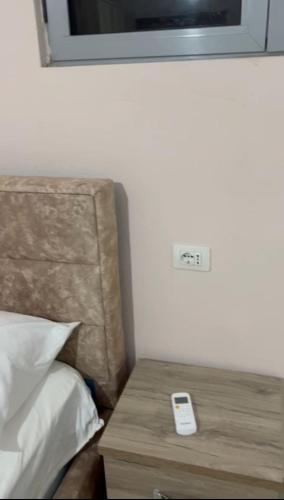 a remote control sitting on a table next to a bed at Guest house Andersoni Dhoma plazhi Andersoni in (( Shën Ded Gjoni ))