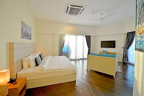 a bedroom with a large bed and a living room at Ramada by Wyndham Langkawi Marina in Kuah