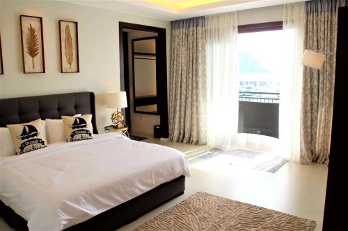 a bedroom with a large bed and a large window at Ramada by Wyndham Langkawi Marina in Kuah