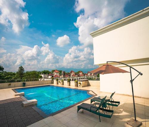 a swimming pool on top of a building with a patio at Barsana Hotel & Resort Siliguri in Siliguri