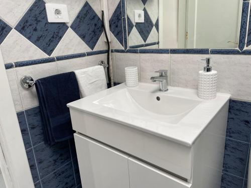 a bathroom with a white sink and a mirror at PLAYMAR Maspalomas Bungalow 124 Bali Style with terrace in Maspalomas