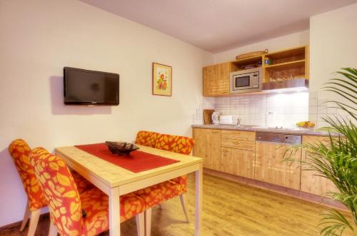 a kitchen with a table and chairs and a tv at Pension Fohrenberg in Ewattingen