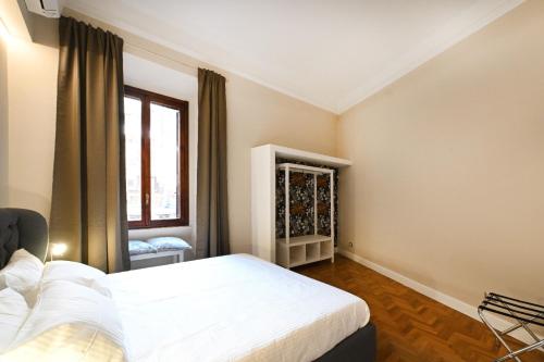 een slaapkamer met een wit bed en een raam bij St Peter Regal Apartment in Rome