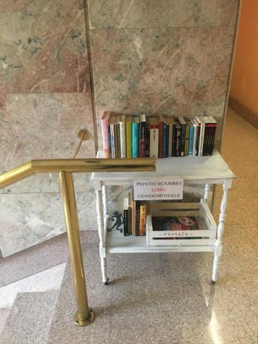 a table with a shelf with books on it at Morivione Apartment - Bocconi free parking in Milan