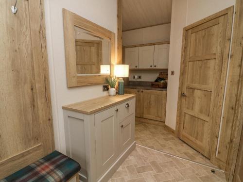 a kitchen with wooden cabinets and a counter with a window at Lindale Lodge in Carnforth