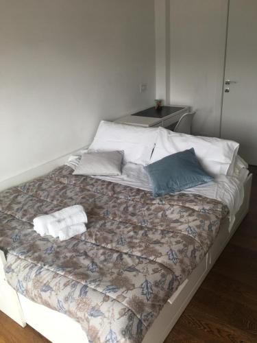 a bed with a blanket and pillows on it at Morivione Apartment - Bocconi free parking in Milan