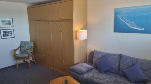 sala de estar con sofá y armario en Haus Metropol App 103, en Westerland