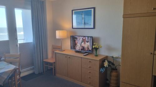 una habitación de hotel con TV en la parte superior de un tocador en Haus Metropol App 103, en Westerland