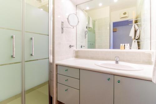 a white bathroom with a sink and a mirror at SELECT'SO HOME - Appartement Vue mer & Pieds dans l'eau - ESTEL-F in Le Lavandou