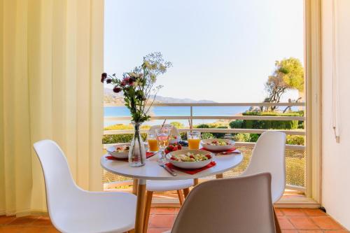 a table with food and flowers on top of a balcony at SELECT'SO HOME - Appartement Vue mer & Pieds dans l'eau - ESTEL-F in Le Lavandou