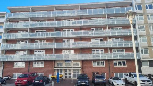 an apartment building with cars parked in front of it at Appartement Andreas-Dirk-Str 1 Appartement 103 in Westerland (Sylt)