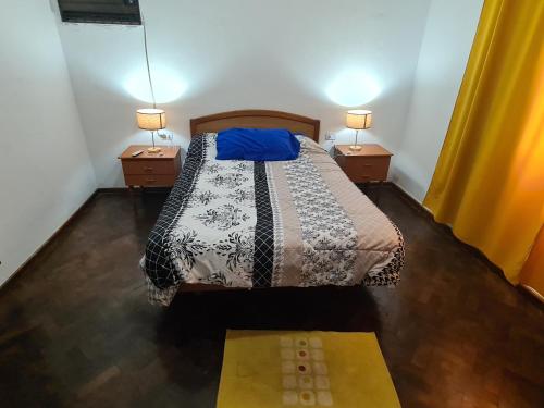 1 dormitorio con 1 cama con 2 mesitas de noche y 2 lámparas en Casa Al pie del Cerro en Yerba Buena