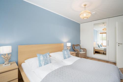 a bedroom with a large bed with blue walls at BeachLife-Strandnahe 3 Zimmer Terrassenwohnung in Pelzerhaken