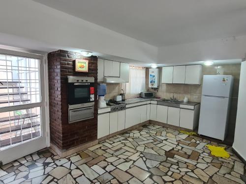 a kitchen with white appliances and a brick wall at Casa Al pie del Cerro in Yerba Buena