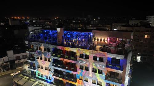 a building with lights on the side of it at night at Rise Street Art Hotel in Larnaca