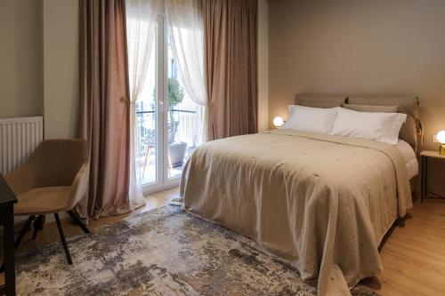 una camera con un letto e una grande finestra di Acropolis Deluxe 2BR Apartment ad Atene