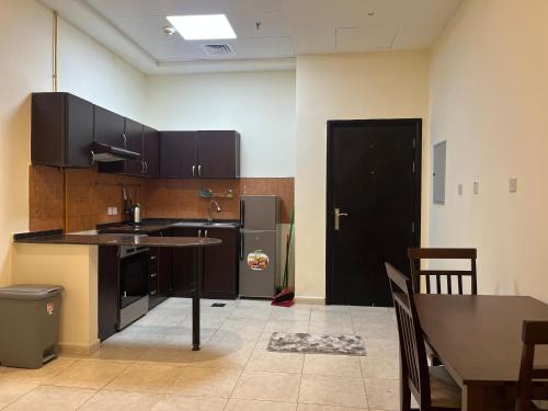 a kitchen with a table and a black door at Jumeirah village circle in Dubai