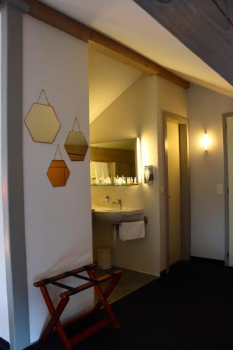 W łazience znajduje się umywalka i lustro. w obiekcie La Clef D'Or Auberge Communale w mieście Bursinel