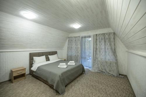 Schlafzimmer mit einem Bett und einem Fenster in der Unterkunft Lake Park in Nowomoskowsk