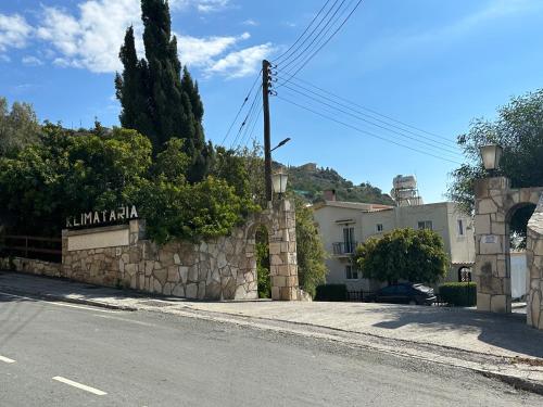 a stone wall next to a street with a building at Klimataria B2 in Pissouri