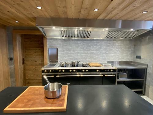 a large kitchen with a stove and a sink at Alpage la Grand Montagne 1858 in Le Grand-Bornand