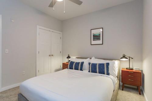 a white bedroom with a bed and a night stand at CozySuites Music Row Spacious 1BR with free parking 60 in Nashville