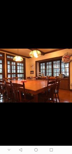 a dining room with a large wooden table and chairs at Pilot Lodge in Hakuba