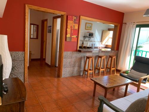 a living room with red walls and a table and chairs at coqueto apto EILA 100 metros playa WIFI in Famara